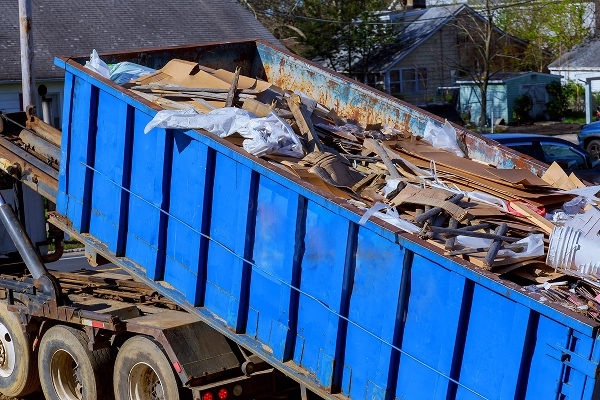 Dumpster filled with debris during bulk trash removal at an apartment community